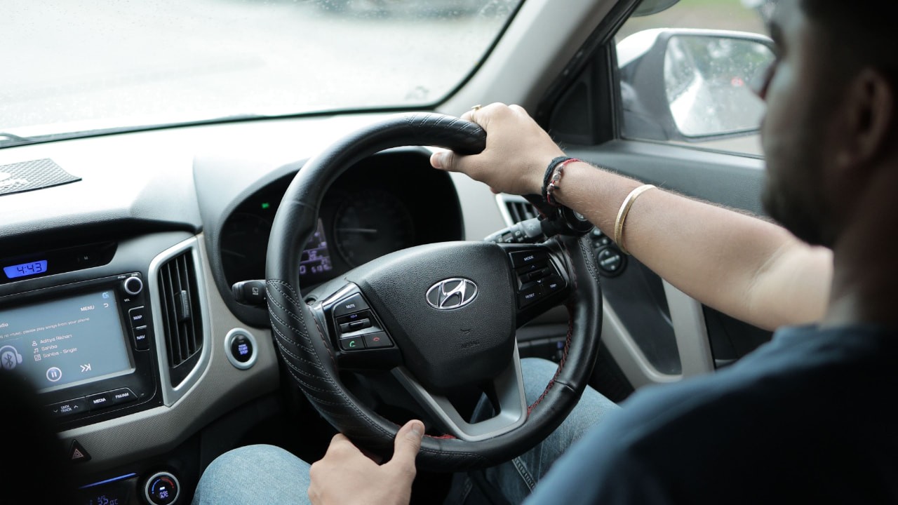 Motorista dirigindo um Hyundai urbano pelo trânsito da cidade